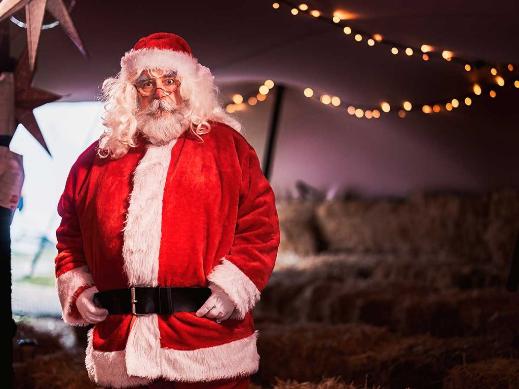Father Christmas inside the stretch tent at Forage, surrounded by twinkling lights, creating a festive and magical atmosphere.