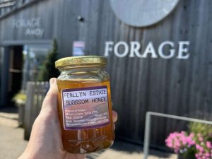 A jar of local Penllyn Estate Welsh honey being held in front of Forage Farm Shop